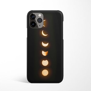 Könnte beinhalten: Schwarze Handyhülle mit einem Design eines zunehmenden Mondes in verschiedenen Phasen, vor einem dunklen Hintergrund.
