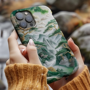 May include: A white and green phone case with a landscape scene of mountains and trees. The case has a raised design and a clear camera lens.