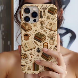 Könnte beinhalten: Eine beige Smartphone-Hülle mit einem sich wiederholenden Muster aus Illustrationen im Vintage-Stil, darunter Bücherstapel, aufgeschlagene Bücher mit botanischen Skizzen, Kaffeetassen, Blumenvasen, eine Brille, eine Feder, ein Tintenfass und eine Kerze.