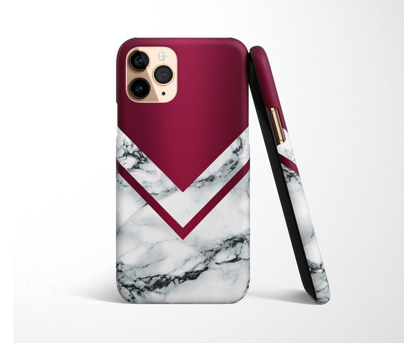 May include: A white and burgundy phone case with a marble pattern and a geometric design. The case has a raised camera bump and a gold accent.