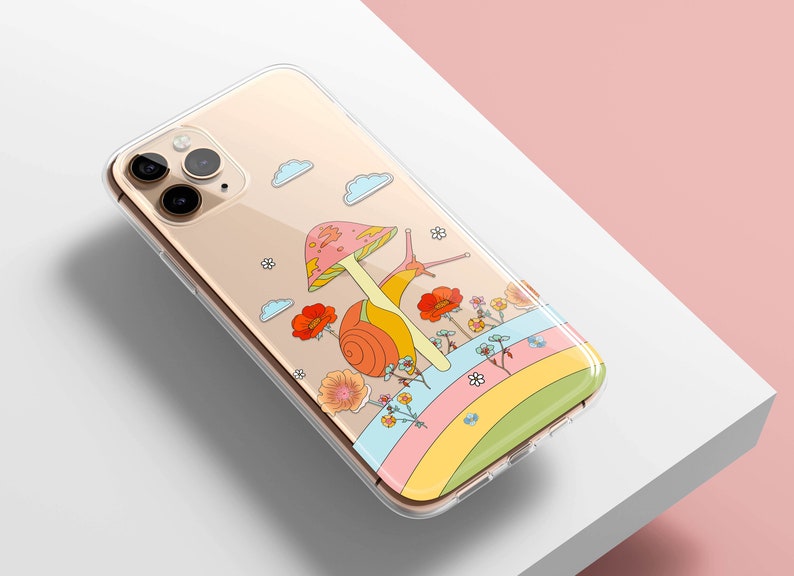 May include: Clear phone case featuring a whimsical illustration of a snail with a mushroom cap, flowers, and a rainbow. The design has a retro, psychedelic vibe. The case is designed for a smartphone.