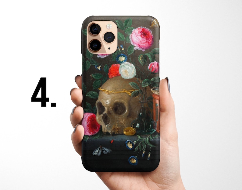 Pode incluir: Uma capa de telefone com uma pintura de uma caveira, flores e um pequeno rel&oacute;gio de areia. A caveira &eacute; cercada por flores rosa, brancas e vermelhas. O fundo &eacute; verde escuro e preto.