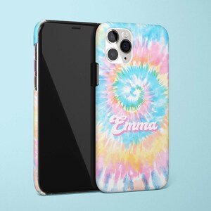 May include: A smartphone and a phone case with a tie-dye design in shades of blue, pink, and yellow. The name "Emma" is printed on the case in a pink and white font. The phone is black.