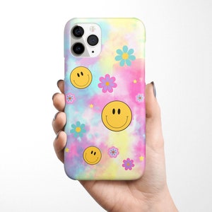 May include: A phone case with a tie-dye background and yellow smiley faces and pink, blue, and purple flowers.