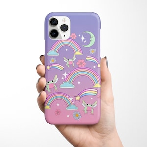 May include: A purple and pink phone case featuring a rainbow, stars, a crescent moon, and frogs. The case has a cut-out for the camera lens.