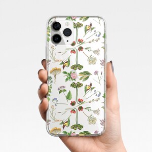 May include: Clear phone case with a floral pattern featuring various flowers and plants in shades of green, yellow, pink, and red.