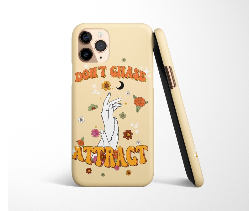 Może przedstawiać: Ż&oacute;łte etui na telefon z kwiatowym wzorem i tekstem "Don't Chase Attract" w retro czcionce. Etui zawiera p&oacute;łksiężyc i dwie dłonie z splecionymi palcami.
