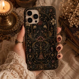 May include: A rectangular smartphone case featuring a dark black background with an intricate, symmetrical floral and botanical pattern in shades of muted red, gold, and green, accented by small star motifs arranged within a decorative arched frame.