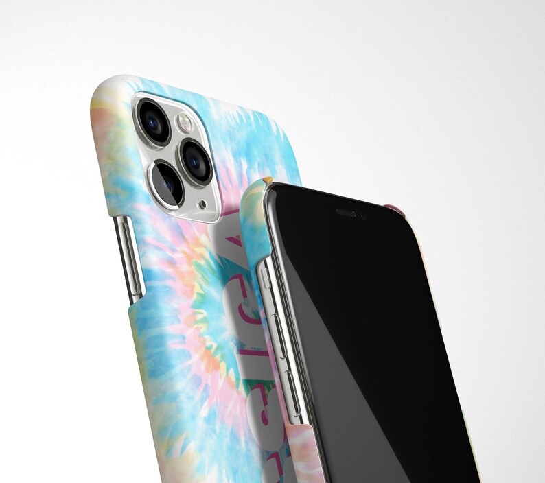 May include: Two iPhone cases, one with a tie-dye pattern and the other black. The tie-dye case has a pink, blue, and yellow swirl pattern. The black case has a silver trim.