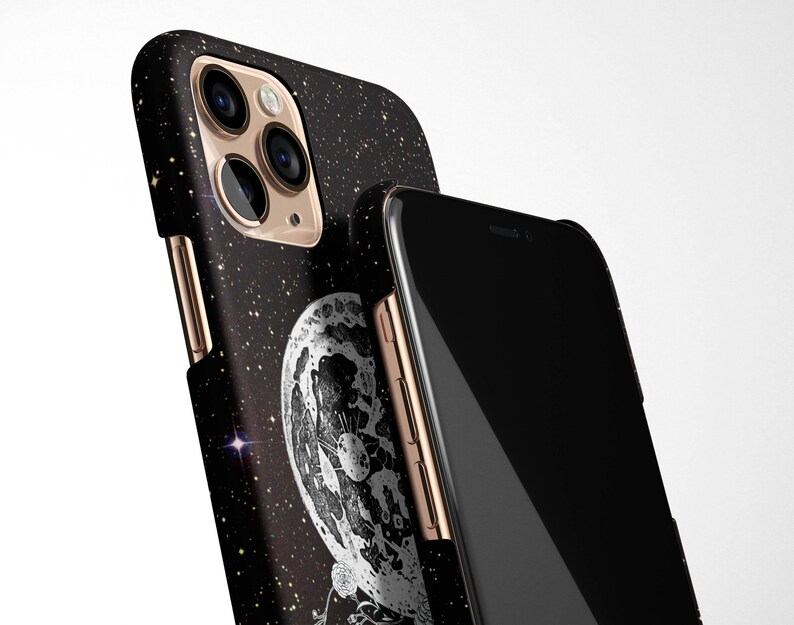May include: A black phone case with a glittery starry night design and a close-up of a moon with craters. The case has a gold trim and a black phone screen.