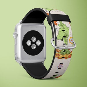 Puede incluir: Un Apple Watch plateado con una banda de cuero blanco con un diseño de rana verde y flores.