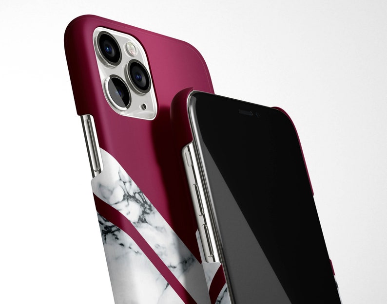 May include: A burgundy and white marble phone case with a black phone inside. The case has a geometric design with a white marble pattern and a burgundy background.