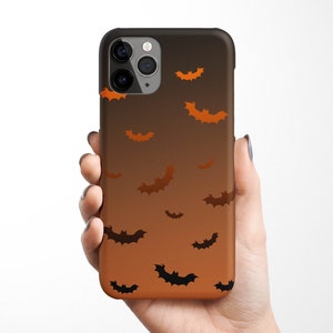 May include: A black phone case with a gradient design of orange and brown. The case has a pattern of black bats flying across the gradient background.