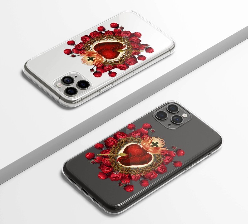 May include: Two clear phone cases with a design of a red heart with thorns and red roses. The heart has a cross on top and an arrow through it.