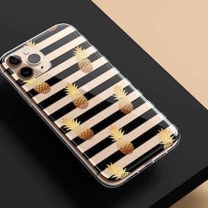 May include: A clear phone case with a black and white striped pattern and gold pineapple accents.