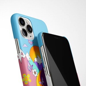 K&ouml;nnte beinhalten: Eine Handyh&uuml;lle mit einem farbenfrohen Design mit Bergen, einer Sonne, Schmetterlingen und Blumen. Die H&uuml;lle ist aus weichem, flexiblem Material und kompatibel mit dem iPhone 13 Pro.
