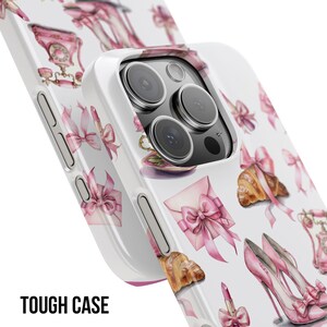 Pode incluir: Capa de telefone branca com um padr&atilde;o repetido de la&ccedil;os rosa, saltos altos, croissants e batom. A capa tem um design protetor e as palavras "TOUGH CASE" s&atilde;o impressas em preto na parte inferior.