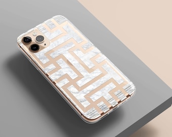 Puede incluir: Una funda transparente para teléfono con un diseño geométrico blanco de mármol y oro. La funda está diseñada para un iPhone.