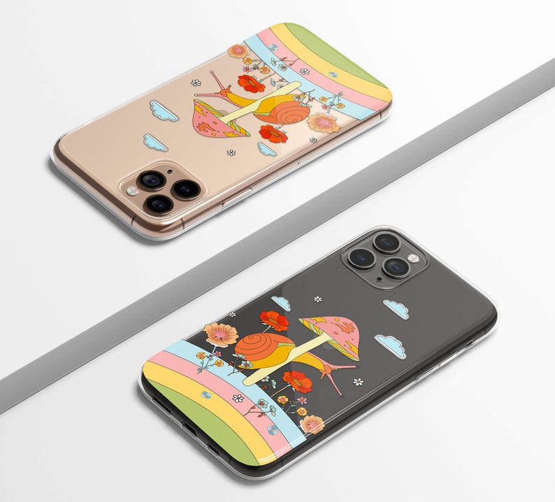 May include: Two clear phone cases with colorful designs. One case features a snail with a mushroom cap, flowers, and a rainbow. The other case has a similar design with a snail, flowers, and a rainbow. The cases are designed to fit a smartphone.