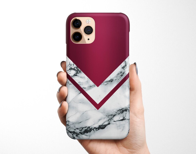 May include: A white marble phone case with a burgundy chevron design. The case has a camera cutout and a sleek, modern look.