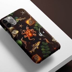 May include: A black phone case with a colorful underwater design featuring an octopus, fish, seahorses, and starfish. The case has a dark background and a variety of colors, including orange, yellow, and blue.