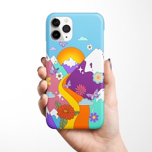 K&ouml;nnte beinhalten: Eine Handyh&uuml;lle mit einem farbenfrohen Design, das eine Bergkette, eine gelbe Sonne, Schmetterlinge und Blumen zeigt. Die H&uuml;lle ist blau mit einem wei&szlig;en Rand.