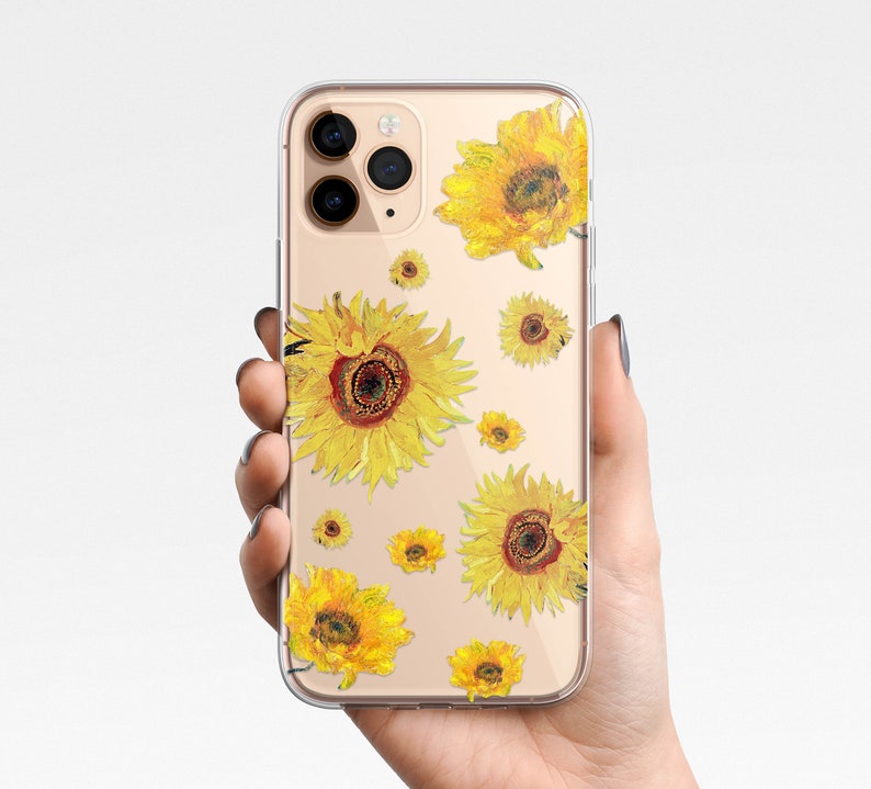 May include: Clear phone case with a design of yellow sunflowers on a white background. The case is designed for an iPhone.