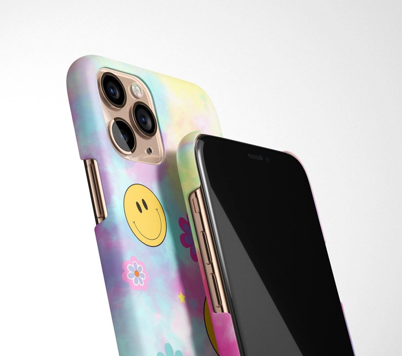 May include: Two phone cases, one with a tie-dye pattern and a smiley face, and the other with a black screen.