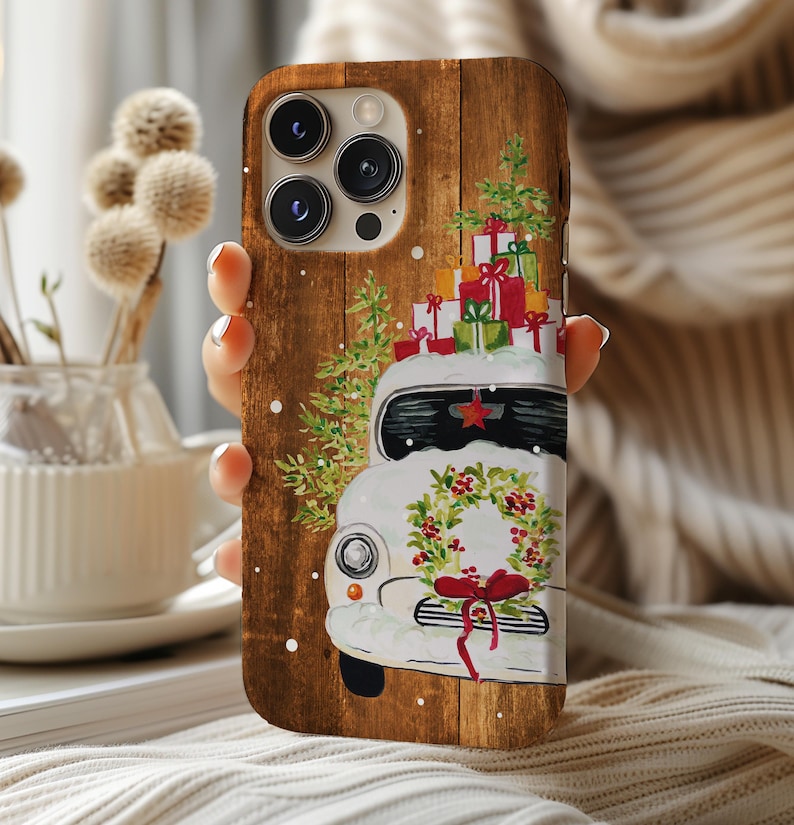 May include: A white vintage car with a wreath and red bow on the front, decorated with Christmas presents and a Christmas tree on top. The car is on a woodgrain background.