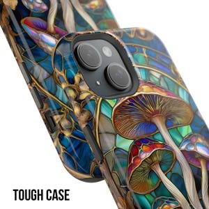 May include: A close-up of a phone case with a colorful mushroom design. The case features a stained-glass style with blue, gold, red, and brown hues. The text "TOUGH CASE" is printed in white at the bottom.