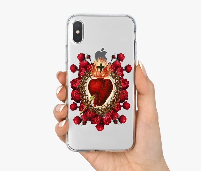 May include: A clear phone case with a design of a red heart with thorns and a cross, surrounded by red roses. The design is a vintage illustration.
