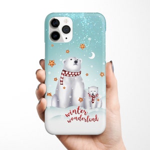 May include: A blue and white phone case with a winter wonderland theme. It features two polar bears, one large and one small, wearing red and white scarves. The case also has a snowflake design and the text "winter wonderland".