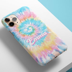 May include: A smartphone case with a colorful tie-dye pattern in shades of blue, pink, yellow, and white. The name "Emma" is printed in a pink script font across the case. The case is on a white surface.