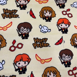 May include: A light yellow fabric featuring a repeating pattern of Harry Potter characters, logos, and symbols. The design includes cartoon illustrations of Harry, Hermione, and Ron, along with the Harry Potter logo, golden snitches, and other themed elements.
