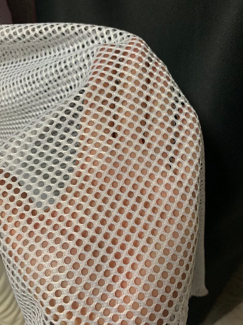 Puede incluir: Tela de malla blanca con un patr&oacute;n de cuadr&iacute;cula fina y uniforme. La tela es suave y flexible, con una superficie ligeramente texturizada.
