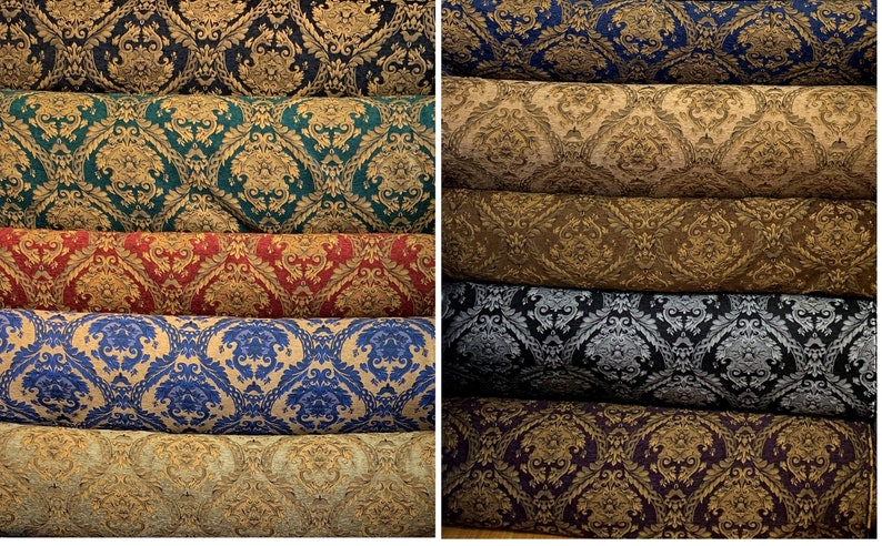 Puede incluir: Rollos de tela con patrones de damasco en varios colores. Las telas muestran un dise&ntilde;o floral detallado en tonos de azul, verde, rojo, dorado y negro, adecuado para tapicer&iacute;a o cortinas.