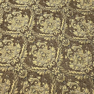 Puede incluir: Primer plano de una tela de damasco marr&oacute;n y dorada. El patr&oacute;n presenta dise&ntilde;os florales y de volutas ornamentados, creando una apariencia lujosa y texturizada. La tela es adecuada para tapicer&iacute;a o fines decorativos.