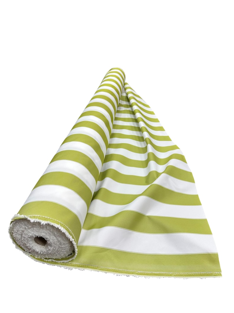 May include: A roll of green and white striped fabric. The fabric is unrolled, revealing the pattern. The stripes are wide and evenly spaced. The fabric is likely cotton or a similar material, suitable for upholstery or crafting.
