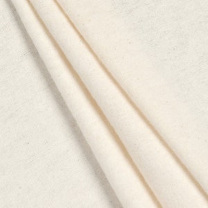 May include: A close-up of a white cotton fabric with a smooth texture. The fabric is folded in a way that shows its natural drape and softness.