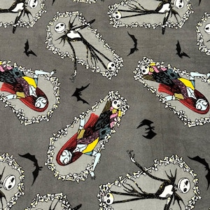 May include: Gray fabric with a repeating pattern featuring characters from The Nightmare Before Christmas. The design includes Jack Skellington in coffins, Sally, and black bat silhouettes. The coffins are outlined with bone-like shapes.