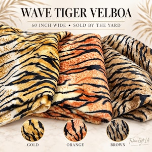 Puede incluir: Tres piezas plegadas de tela Velboa Wave Tiger en colores oro, naranja y marrón, cada una con un patrón de rayas de tigre negras. El texto dice WAVE TIGER VELBOA, 60 INCH WIDE, SOLD BY THE YARD, GOLD, ORANGE, BROWN y Fabric Gift LA.