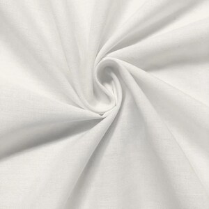 May include: White fabric with a smooth texture, folded and draped to show its soft, flowing quality.