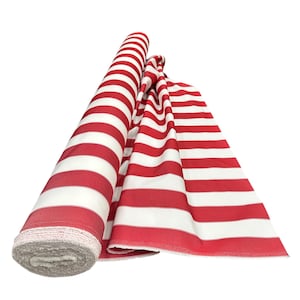 May include: A roll of red and white striped fabric, partially unrolled. The fabric is a bold red with wide white stripes. The edge of the rolled fabric shows a gray, textured material. The fabric is likely used for sewing or crafting projects.
