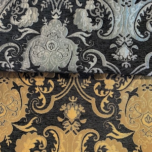 Peut inclure: Tissu noir avec un motif damassé doré et argenté. Le tissu a un aspect texturé et tissé.