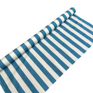 May include: A roll of fabric with alternating white and teal blue stripes. The fabric is partially unrolled, revealing the pattern. The stripes are evenly spaced and run diagonally across the fabric. The background is plain white.