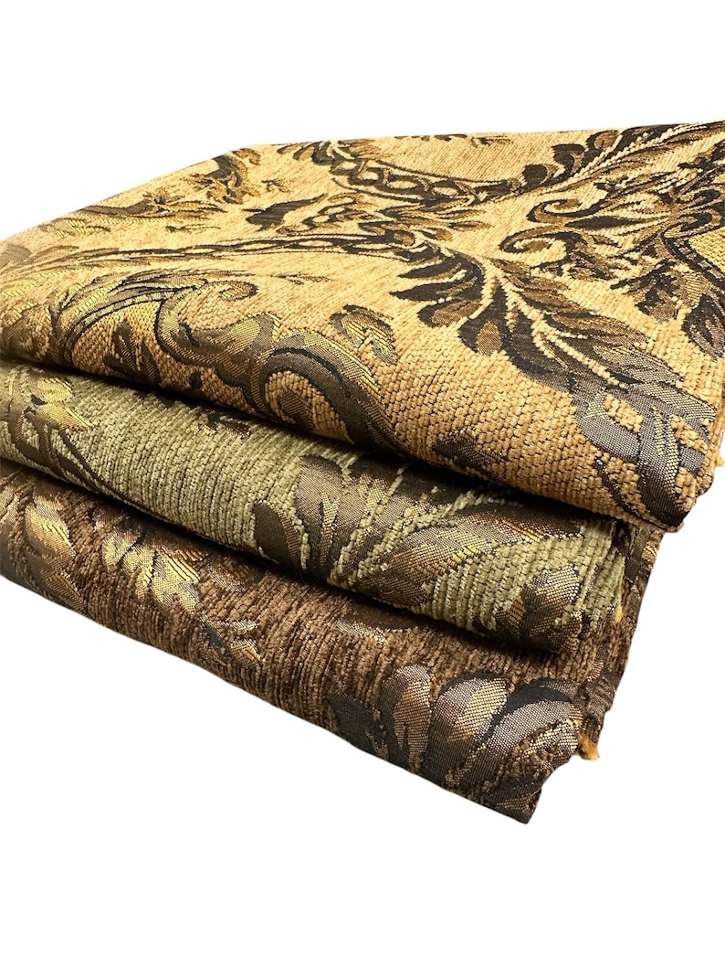 Puede incluir: Tres piezas de tela dobladas con intrincados dise&ntilde;os florales. La tela superior es de color canela con detalles en marr&oacute;n oscuro y dorado. La tela del medio es verde oliva con detalles dorados y marrones. La tela inferior es marr&oacute;n con dorado y marr&oacute;n oscuro.