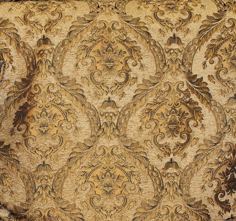 Puede incluir: Primer plano de una tela tejida con un patr&oacute;n de damasco repetido. El dise&ntilde;o presenta motivos florales y de hojas ornamentados y sim&eacute;tricos en tonos dorados, marrones y beige, creando una est&eacute;tica vintage texturizada.