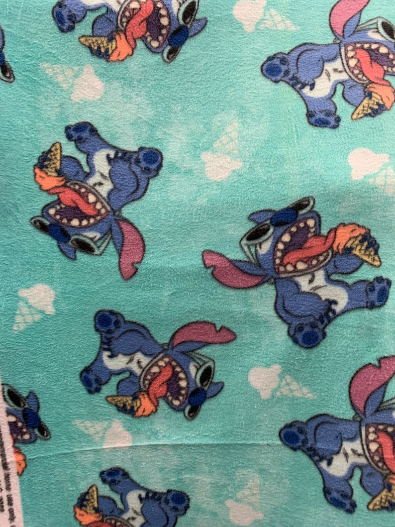 May include: Blue fabric with a repeating pattern of a cartoon character holding an ice cream cone. The character is wearing sunglasses and has a toothy grin. The background is a light blue colour.