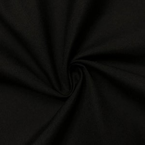 May include: Black fabric with a smooth, woven texture. The fabric is folded and draped, showing its soft and pliable nature.