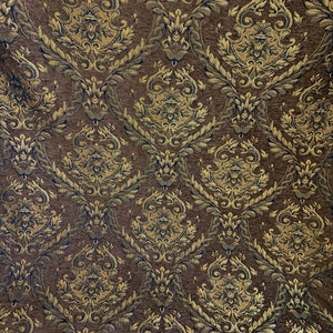 Puede incluir: Primer plano de una tela marr&oacute;n con un estampado damasco dorado y azul marino. El dise&ntilde;o ornamentado presenta hojas y motivos florales en espiral, creando una apariencia lujosa y texturizada. La tela es adecuada para tapicer&iacute;a o cortinas.